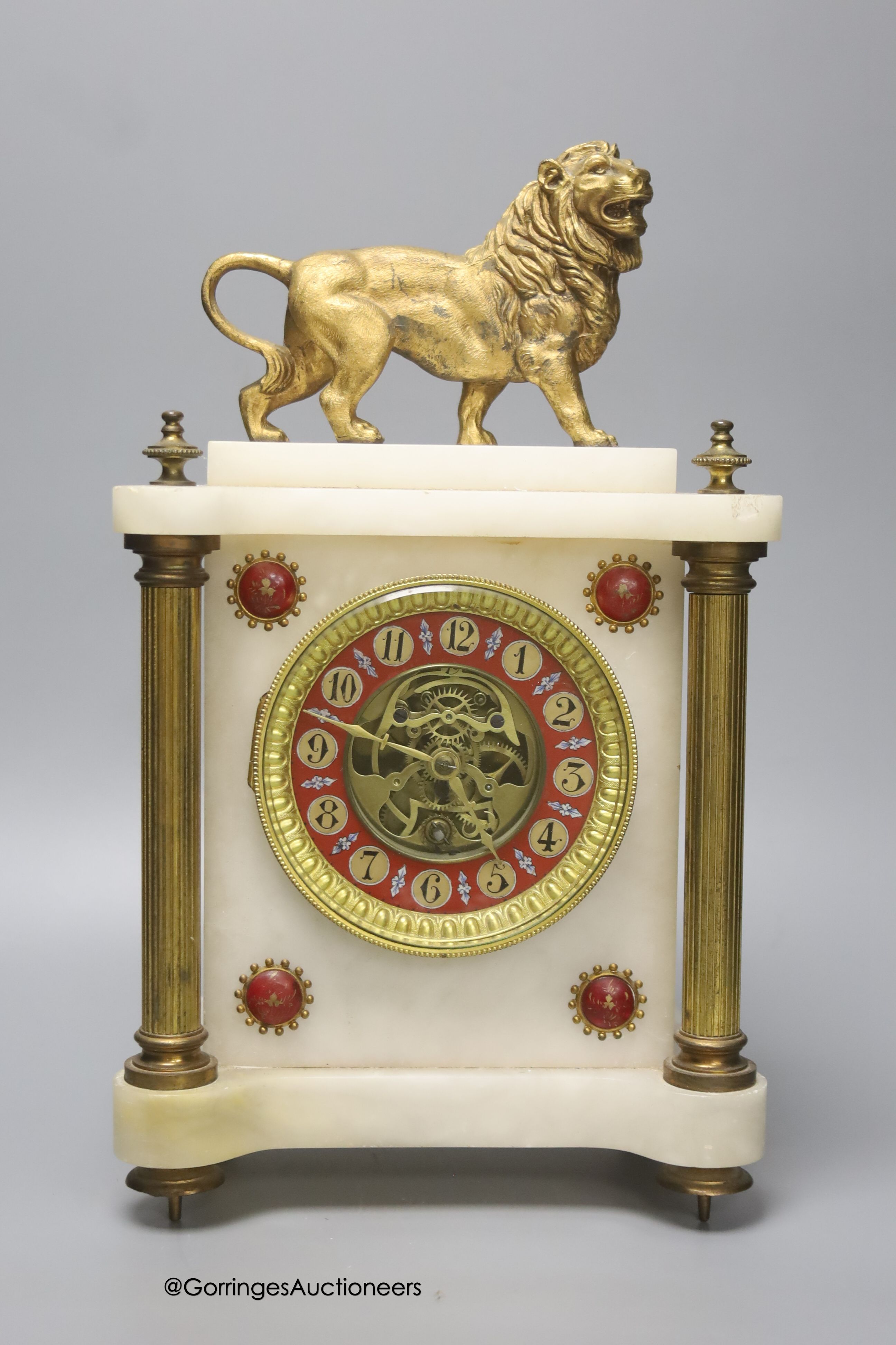 A Victorian alabaster mantel clock, with gilt metal lion surmount, French skeleton movement with pendulum, 34cm